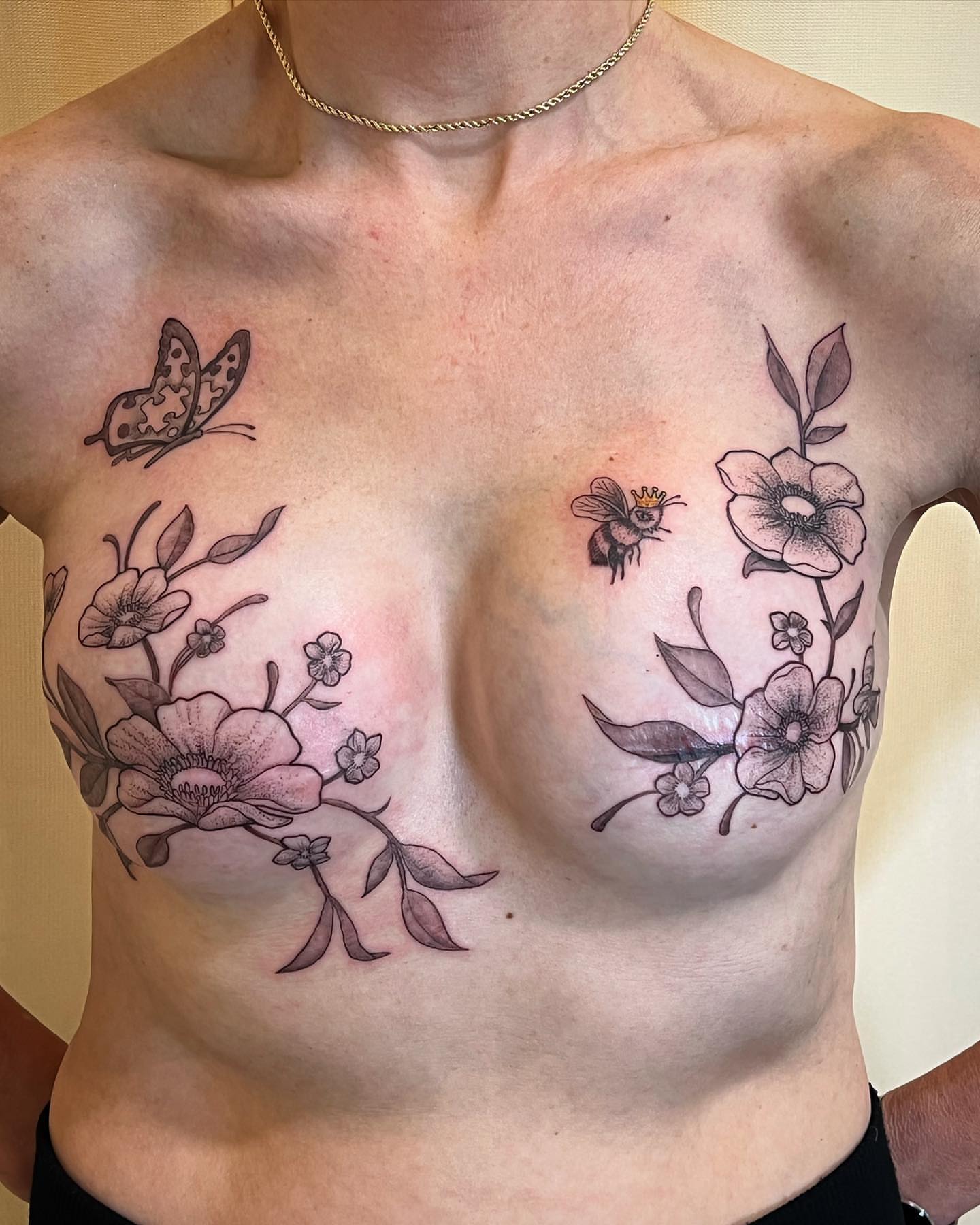 Floral and insect motifs black and grey tattoo on the chest by Iconic Ink, Millbury, Massachusetts
