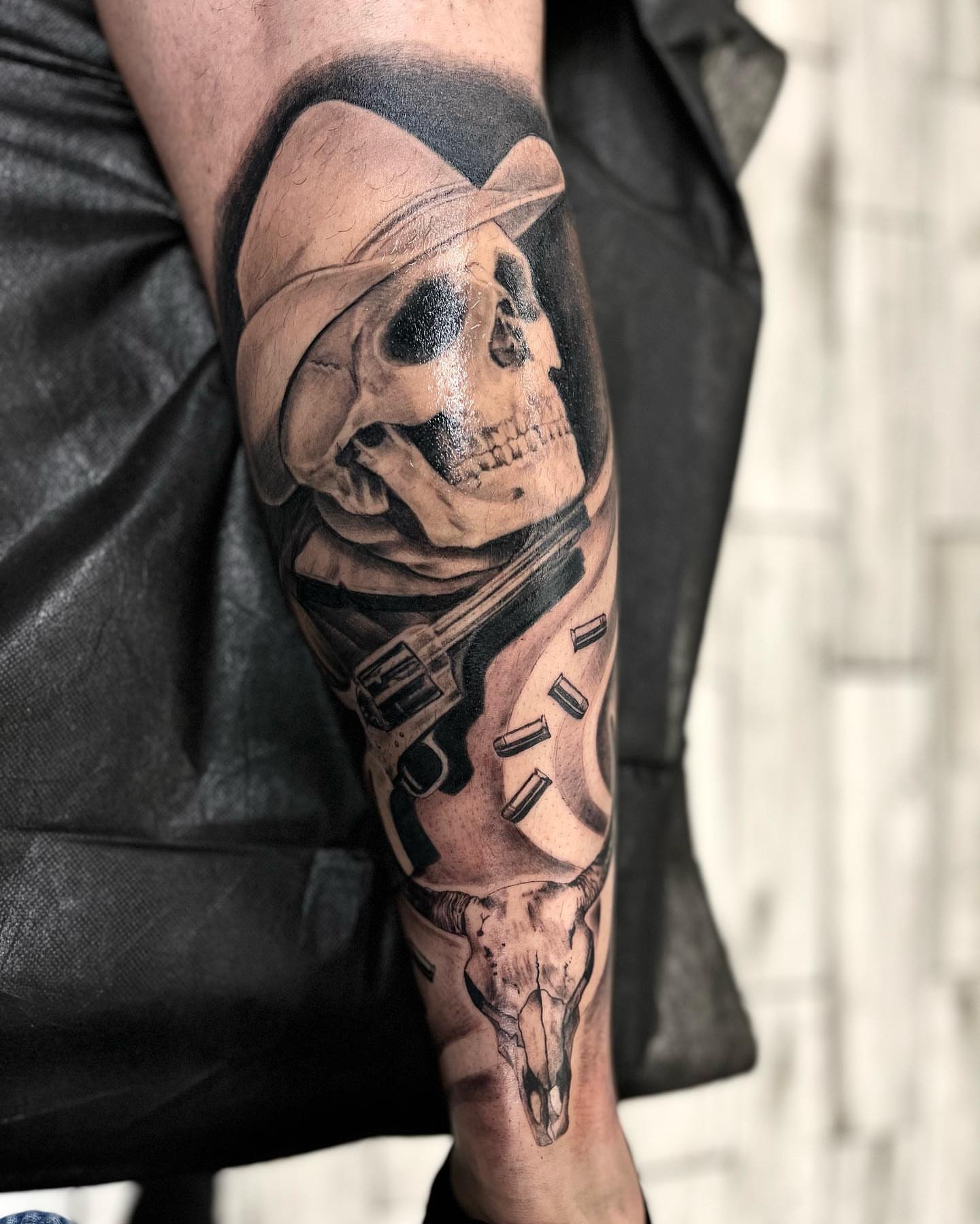 Skull with hat and gun realism tattoo on the forearm by Monique Ortiz, Mesa, Arizona
