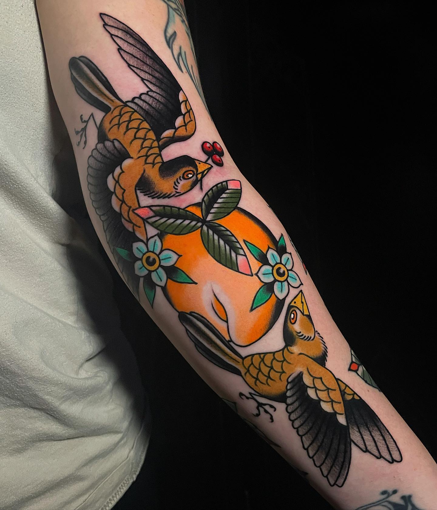 Birds and flowers American traditional tattoo on the forearm by Frank Mostek
