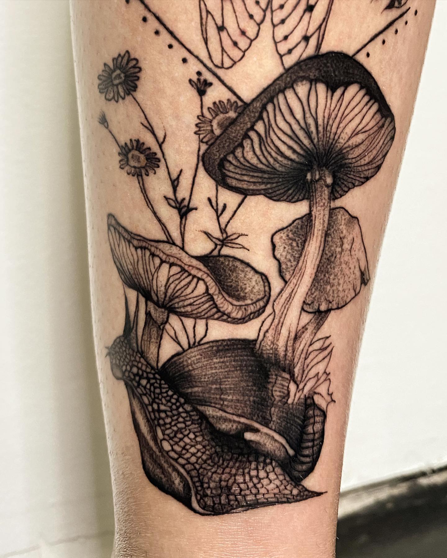 Mushrooms and flowers dotwork tattoo on the forearm by Cindy Xu