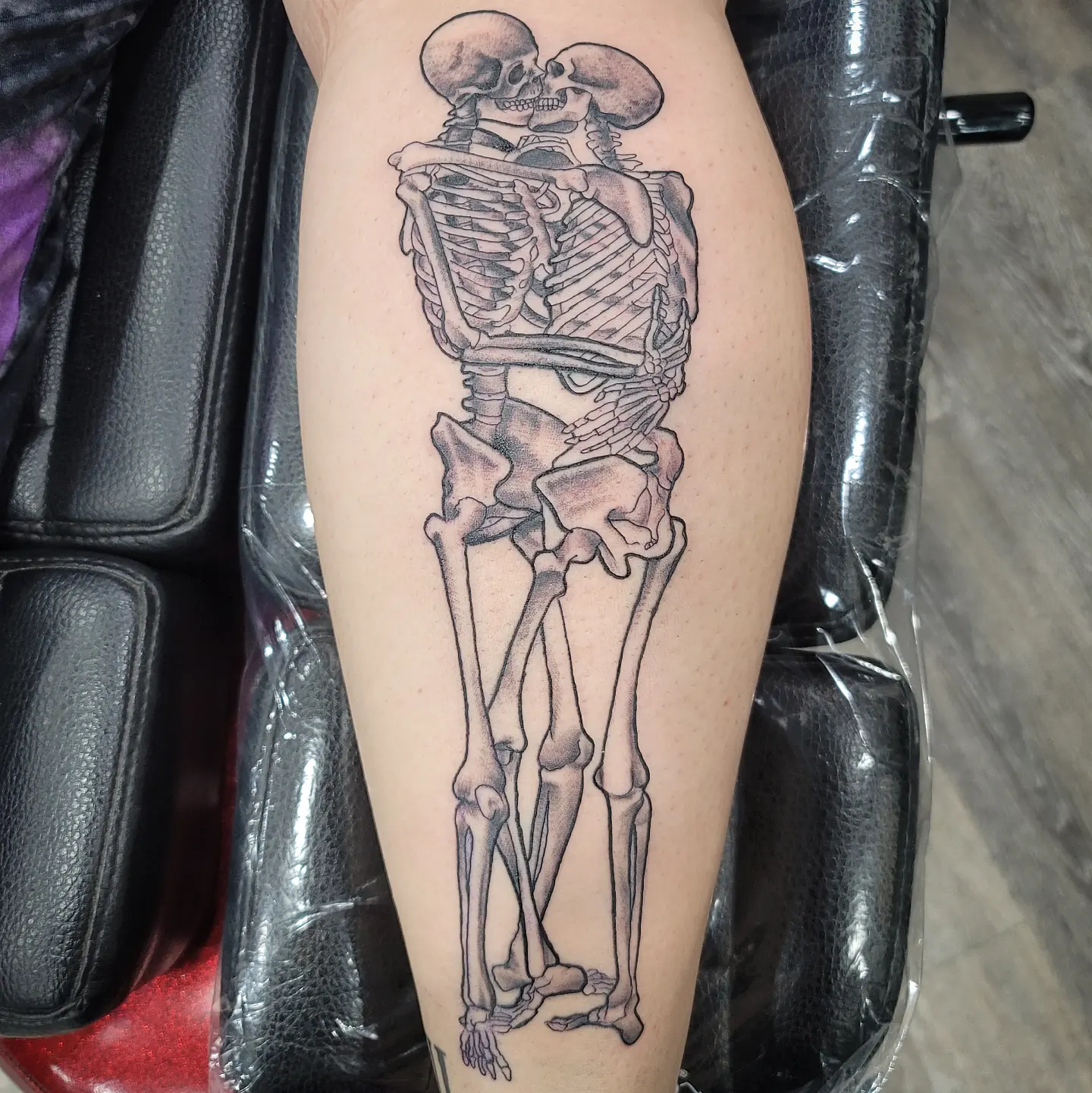 Skeleton couple realism tattoo on the thigh by Dick Eckman
