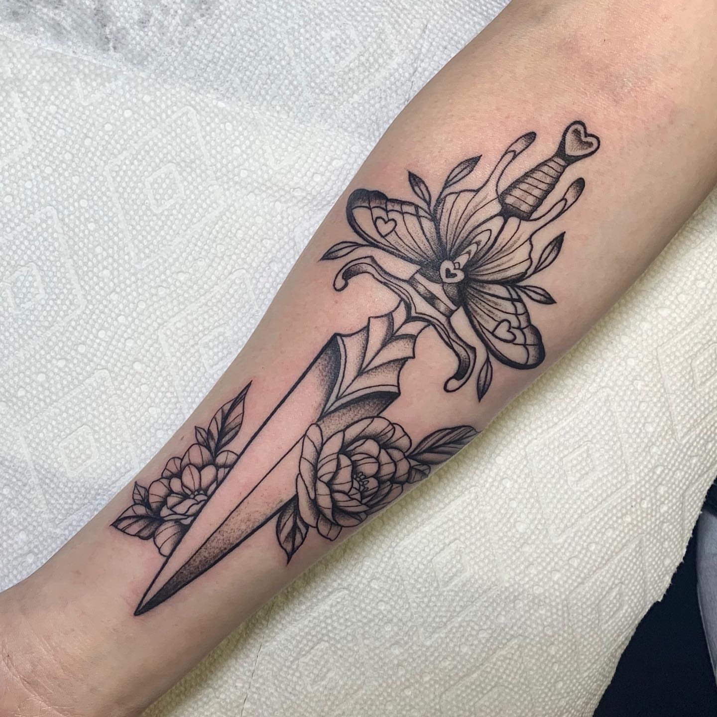 Knife and flowers black and grey tattoo on the forearm by 🤎Dannon 🕸