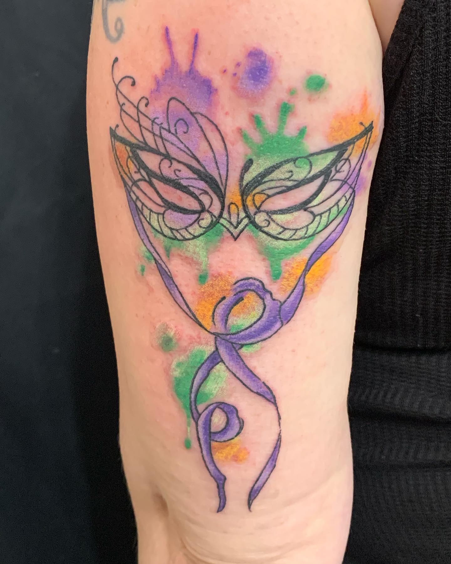 Mask watercolor tattoo on the forearm by IdleHandsFlex, New Orleans, Louisiana