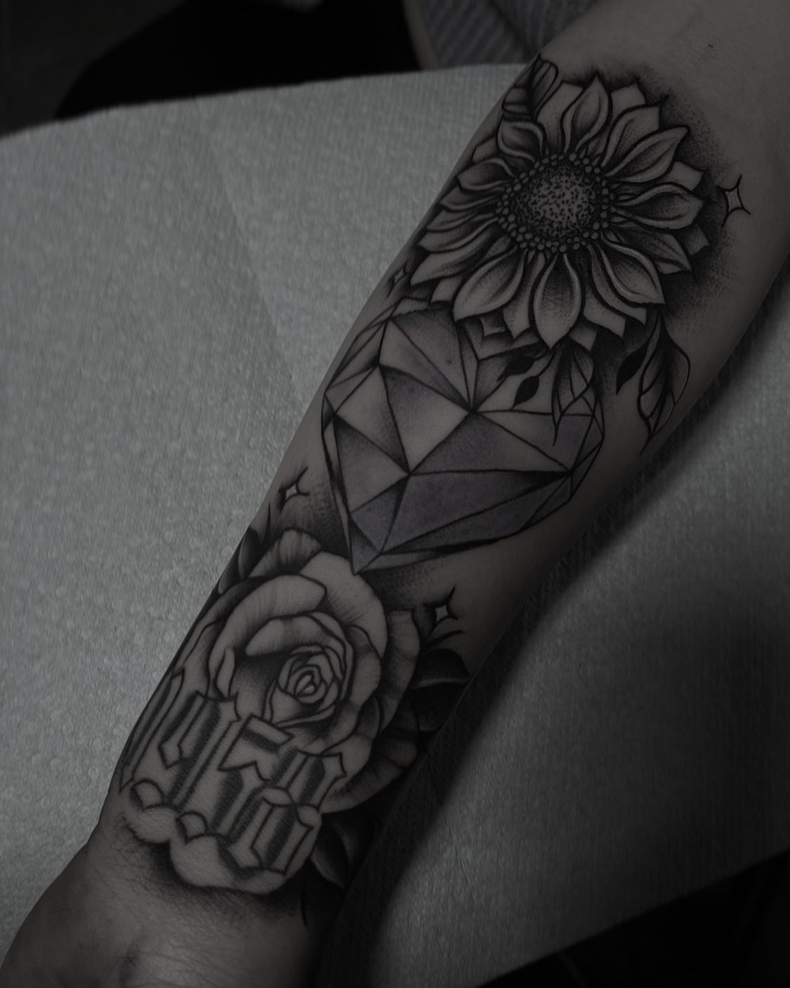 Sunflower and diamond geometric tattoo on the forearm by Las Vegas Tattoo Artist