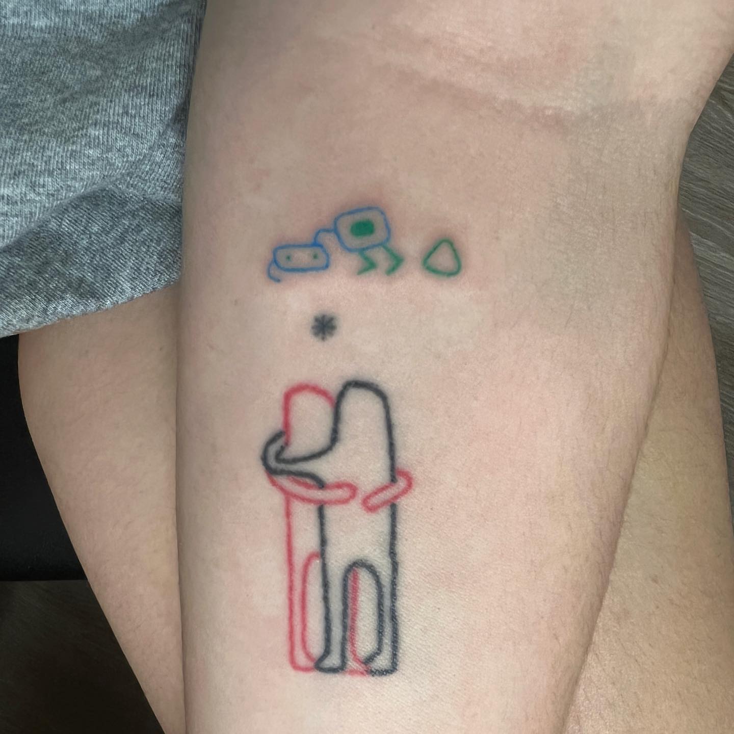 Stick figure hugging minimalist tattoo on the forearm by mars