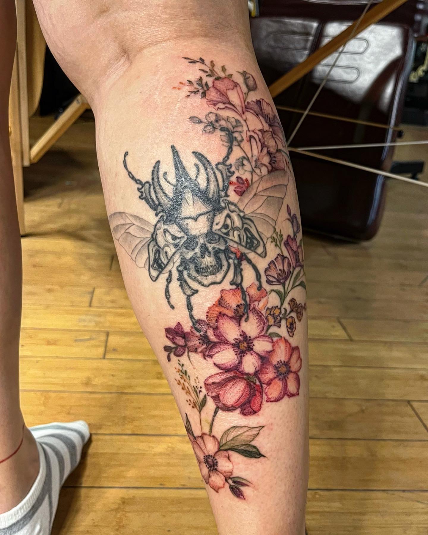 Skull and flowers new school tattoo on the forearm by Sarah Spread