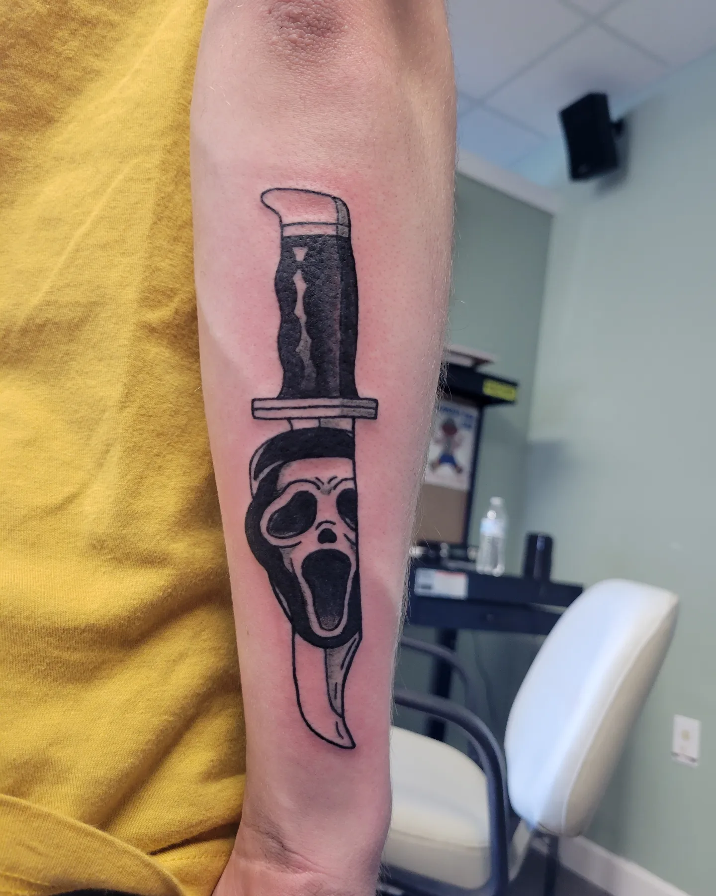 Scream mask knife black and grey tattoo on the forearm by Nicole Bett