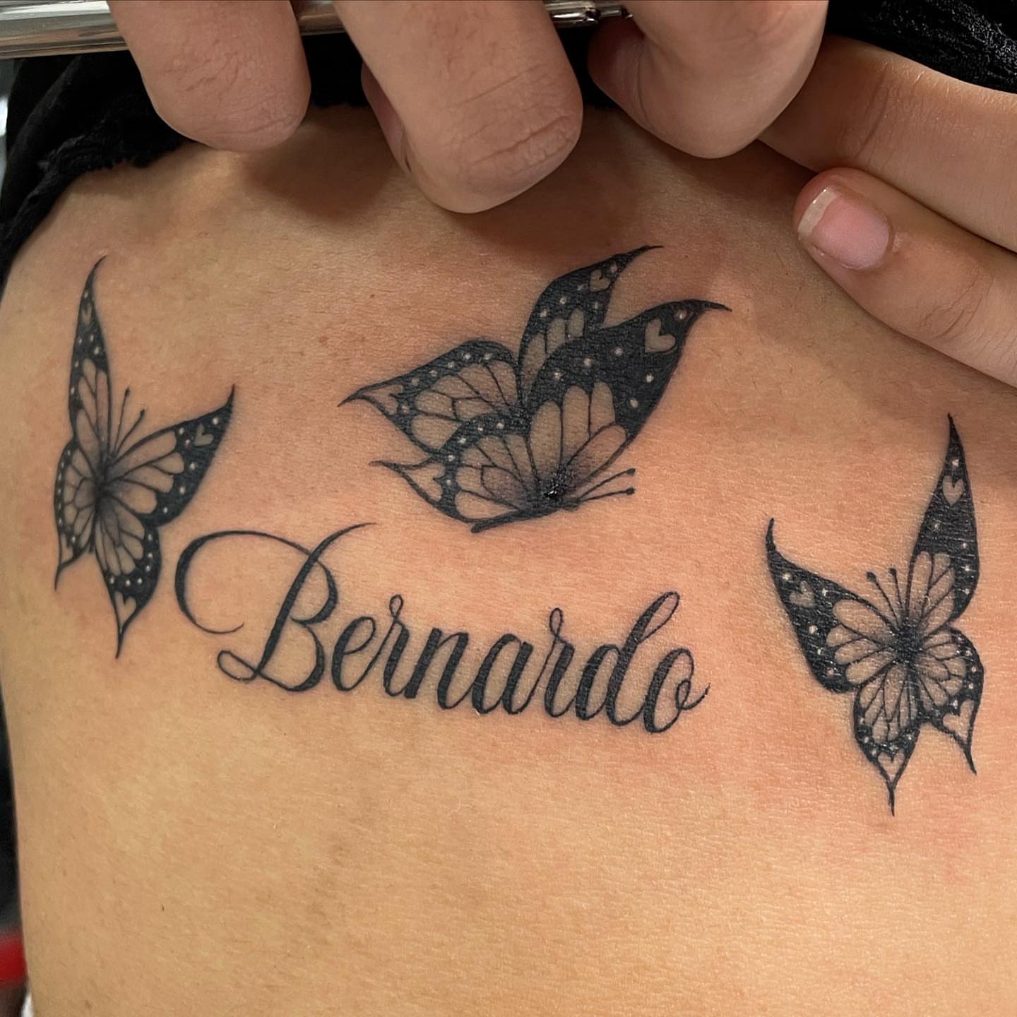 Name with butterflies black and grey tattoo on the back by Yari, Los Angeles, California