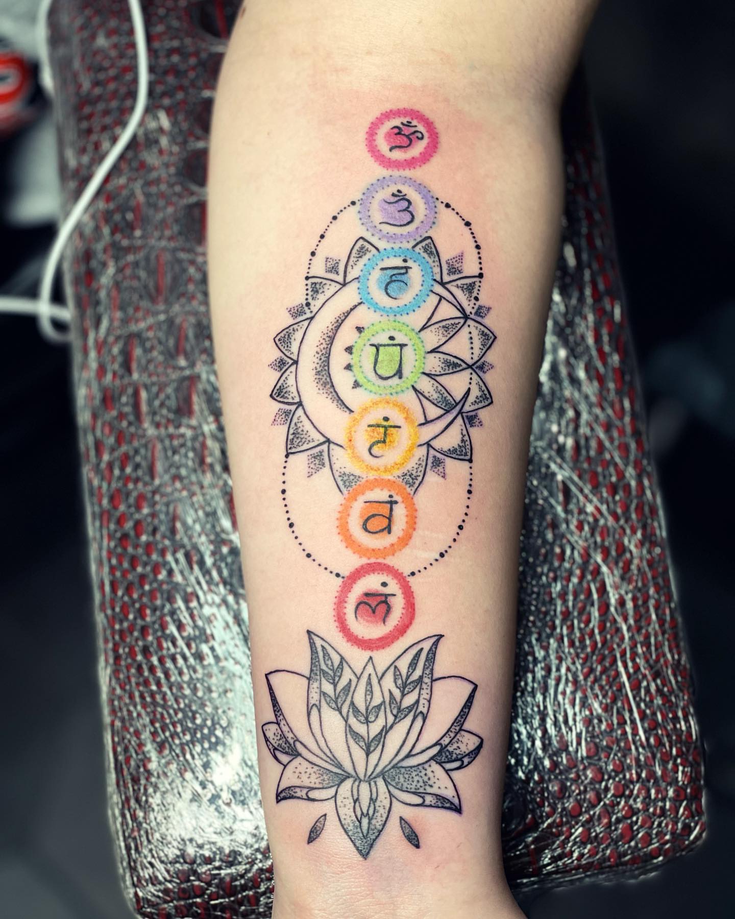 Chakra symbols dotwork tattoo on the forearm by Peewee Morales