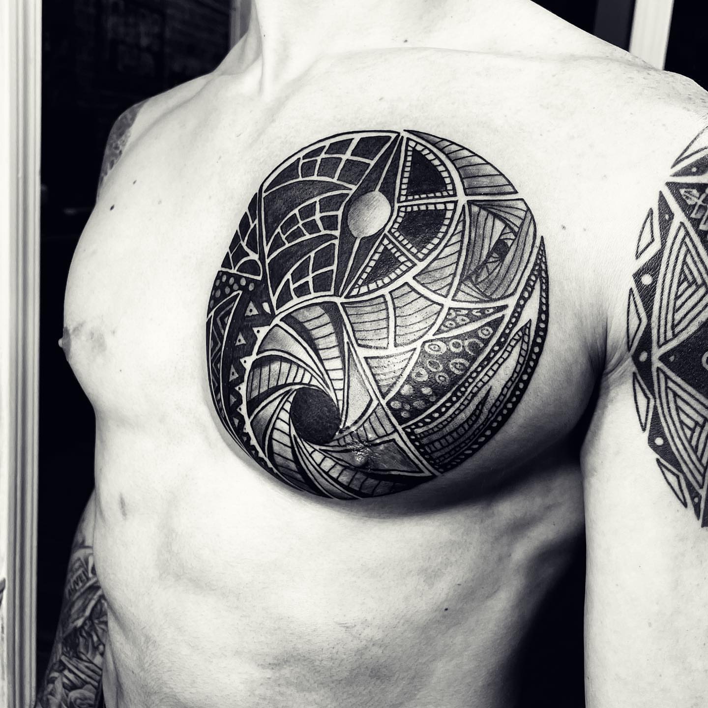 Geometric pattern geometric tattoo on the chest by Peewee Morales