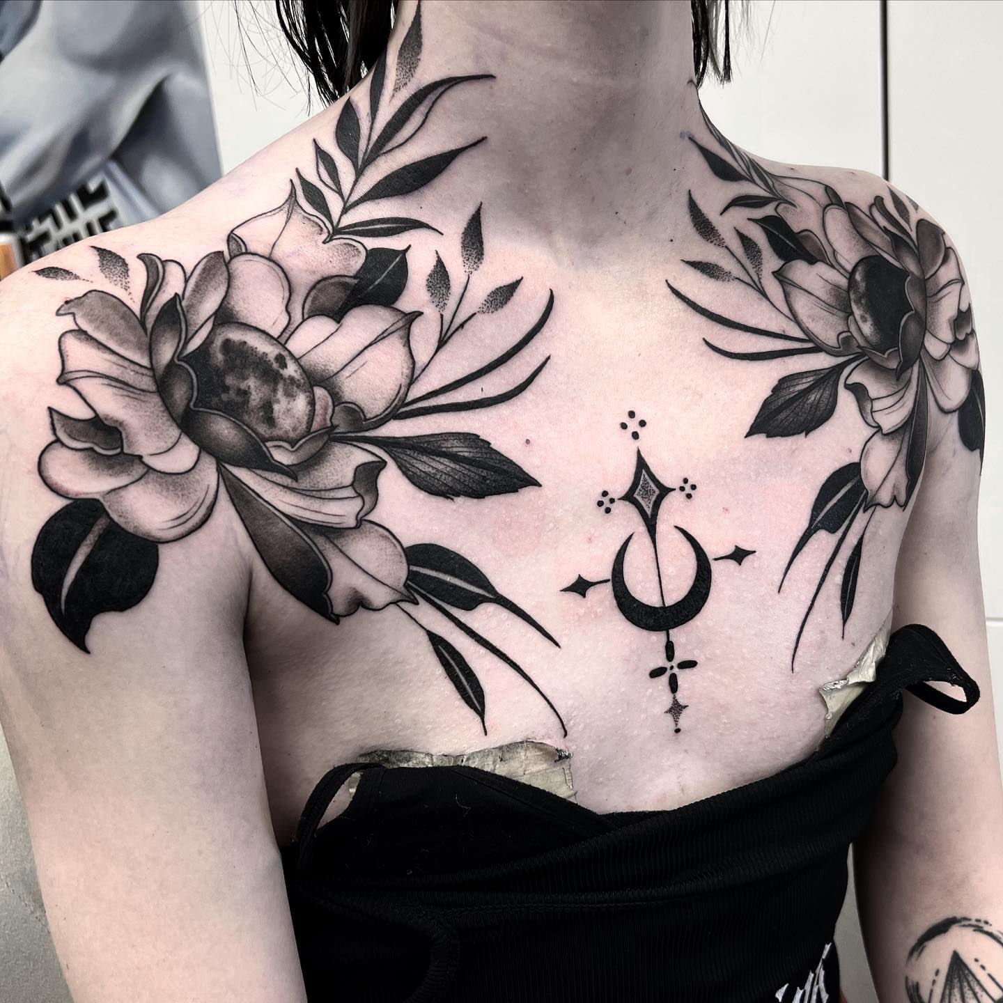 Floral and celestial geometric tattoo on the chest by Briana Walker