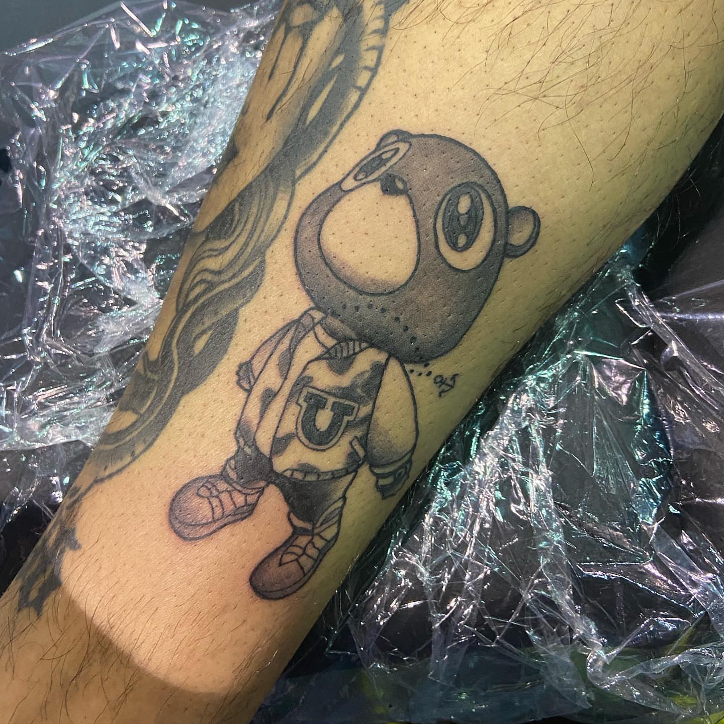Robot character black and grey tattoo on the forearm by Moose