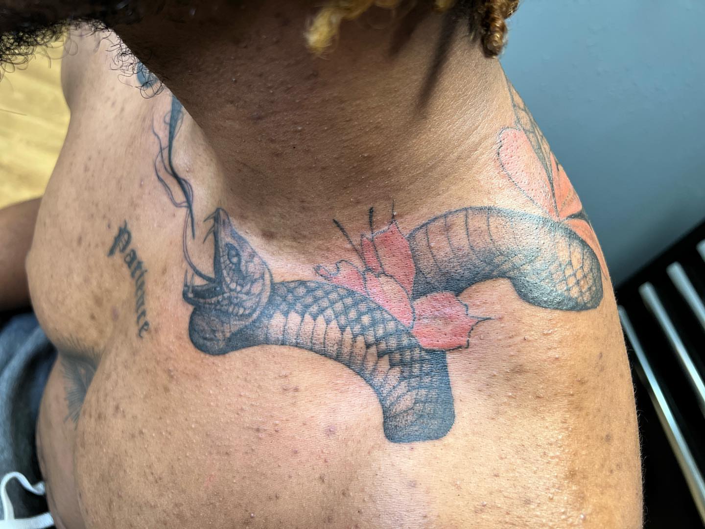 Snake and peony American traditional tattoo on the chest by Emily Jestine Francis