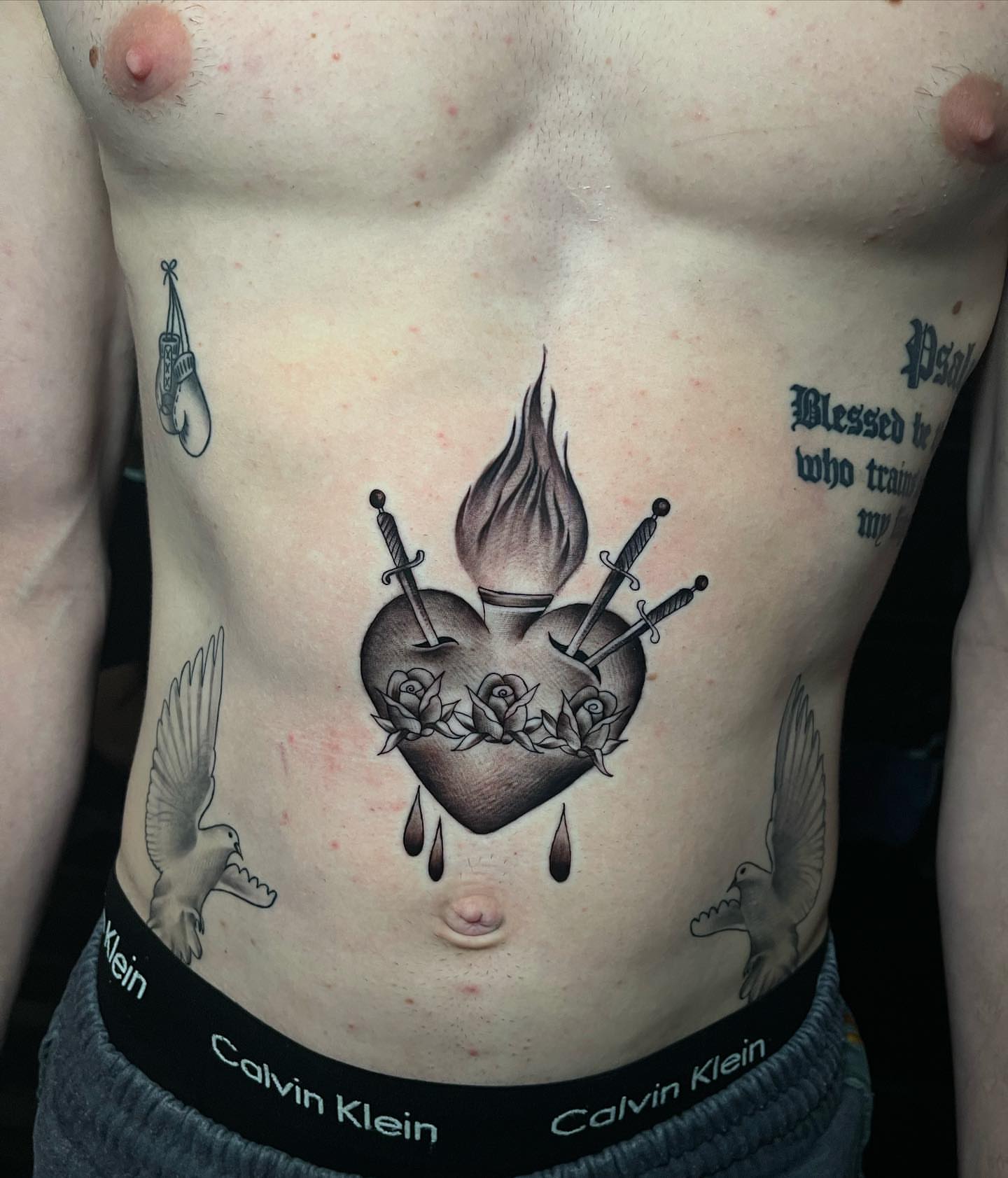 Burning heart with swords American traditional tattoo on the torso by George Maldonado Austin, Austin, Texas