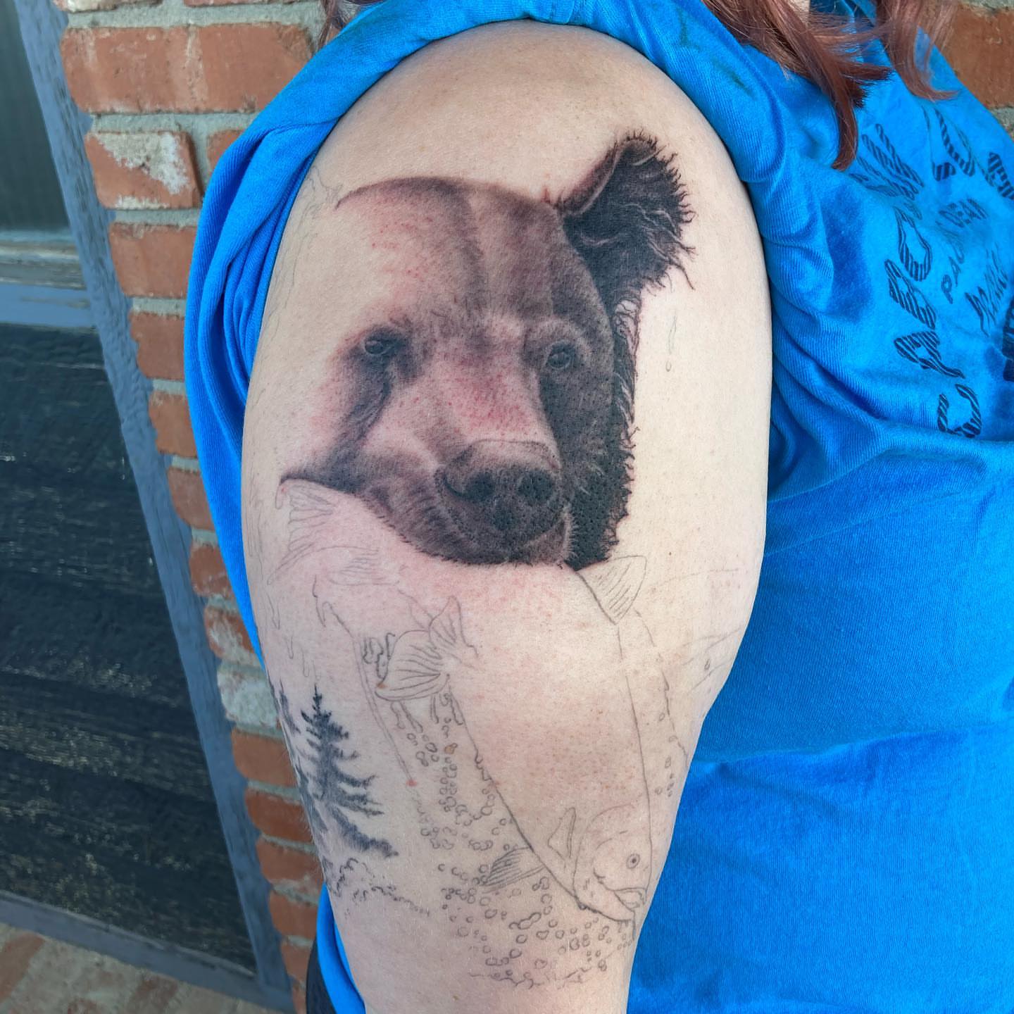 Bear realism tattoo on the upper arm by Chuck House
