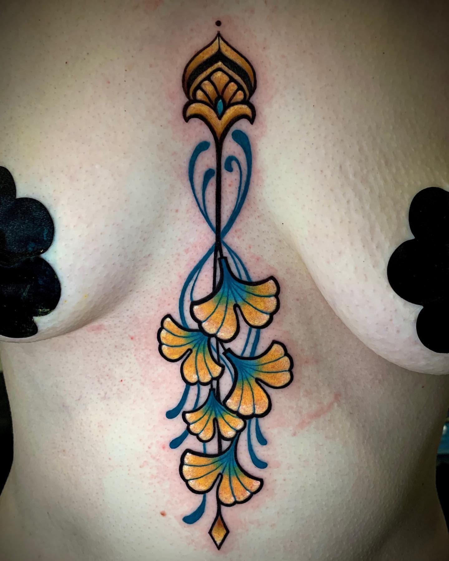 Gingko leaves ornamental tattoo on the chest by Cortney Norton