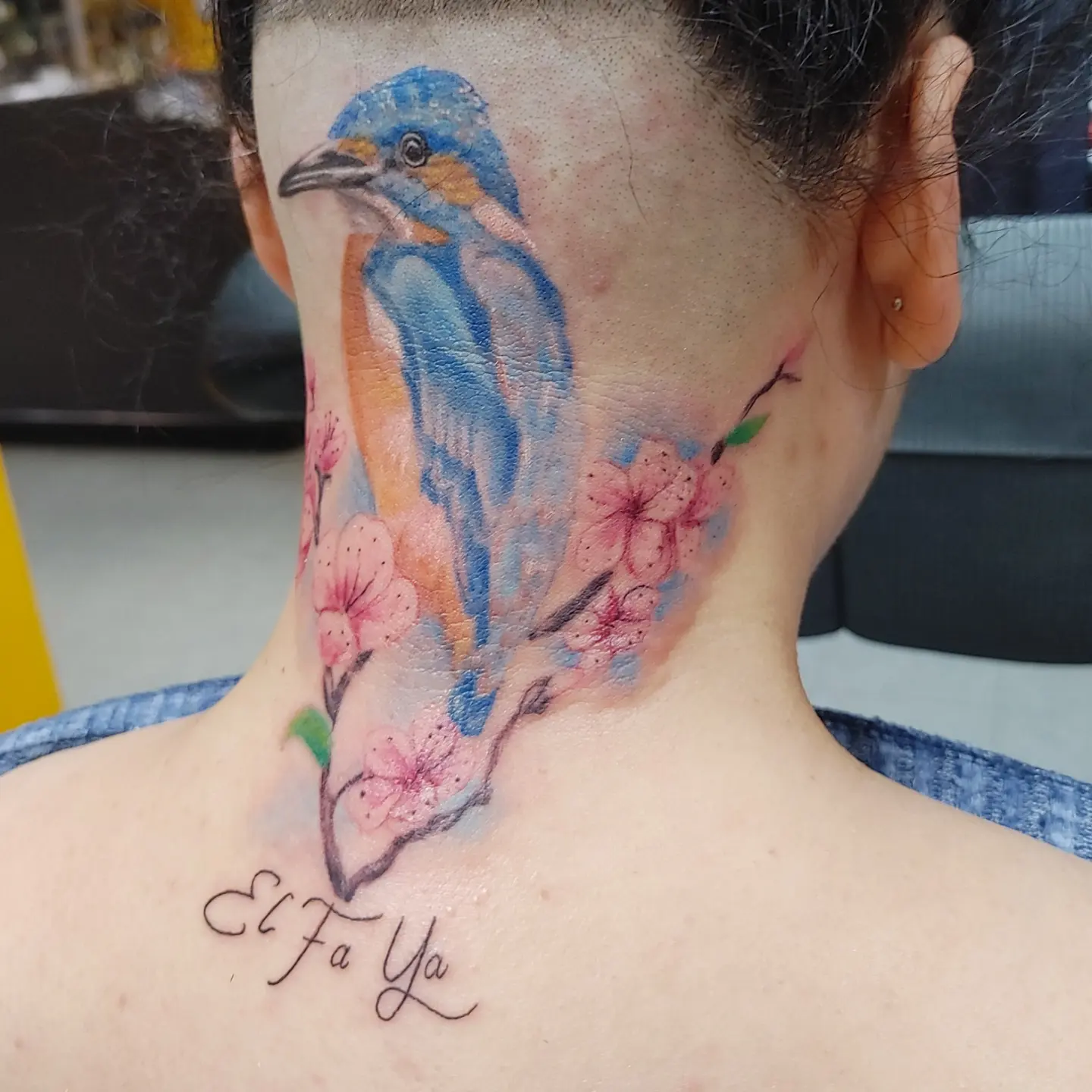 Bird and cherry blossoms watercolor tattoo on the neck by Mike Stamper