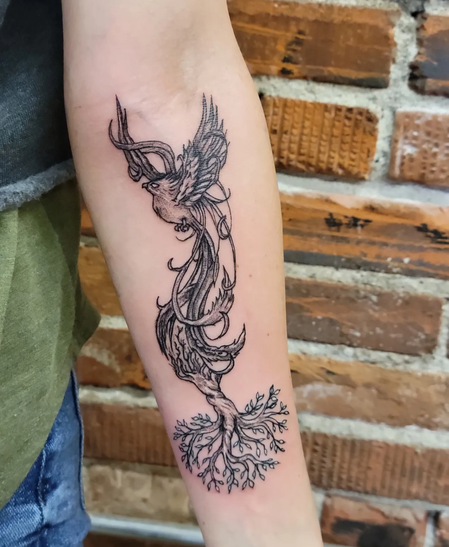 Phoenix black and grey tattoo on the forearm by Tim Andrews
