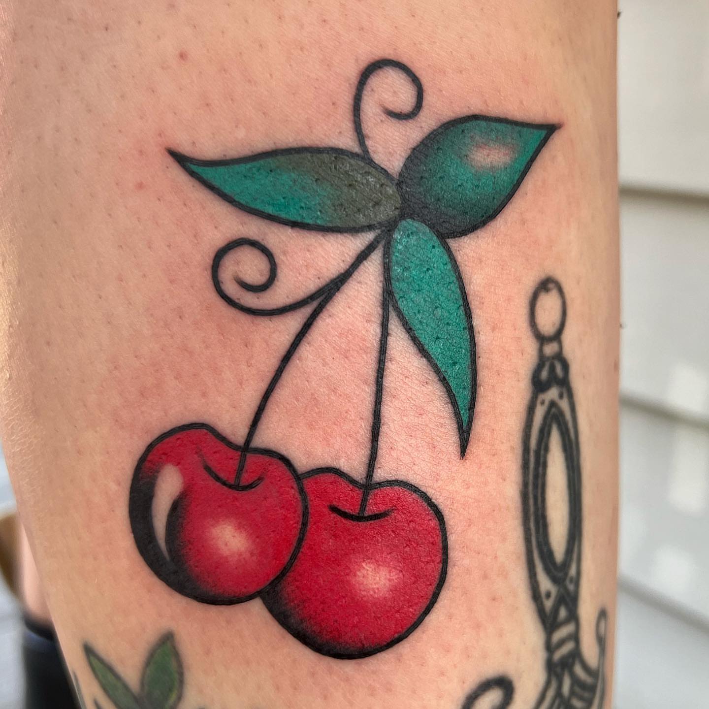 Cherries American traditional tattoo on the forearm by Daniel Mesen