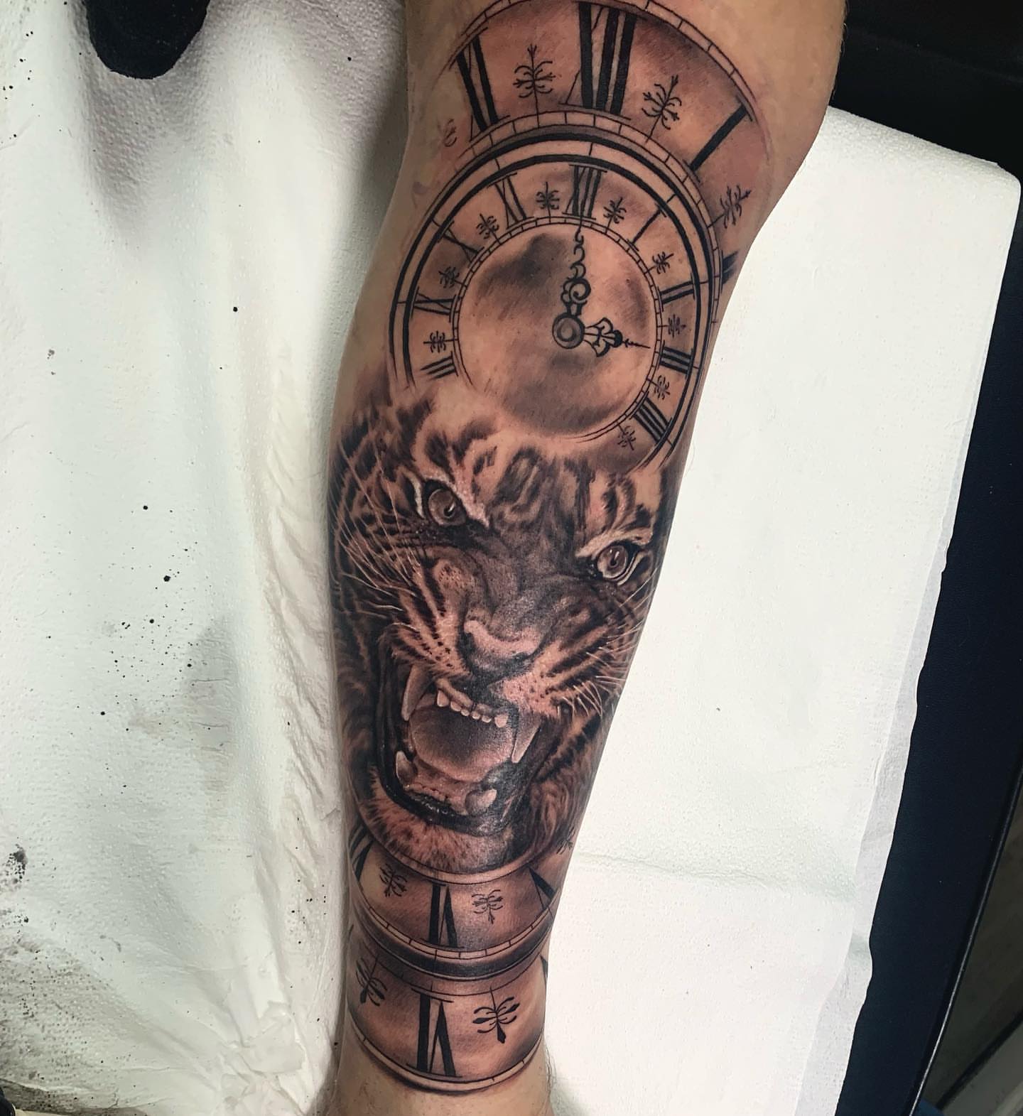 Tiger clock realism tattoo on the forearm by Trevor Sibary