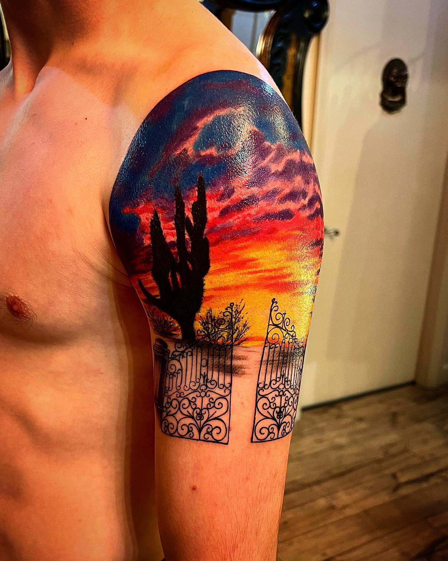 Desert sunset realism tattoo on the upper arm by Cj Hurtado