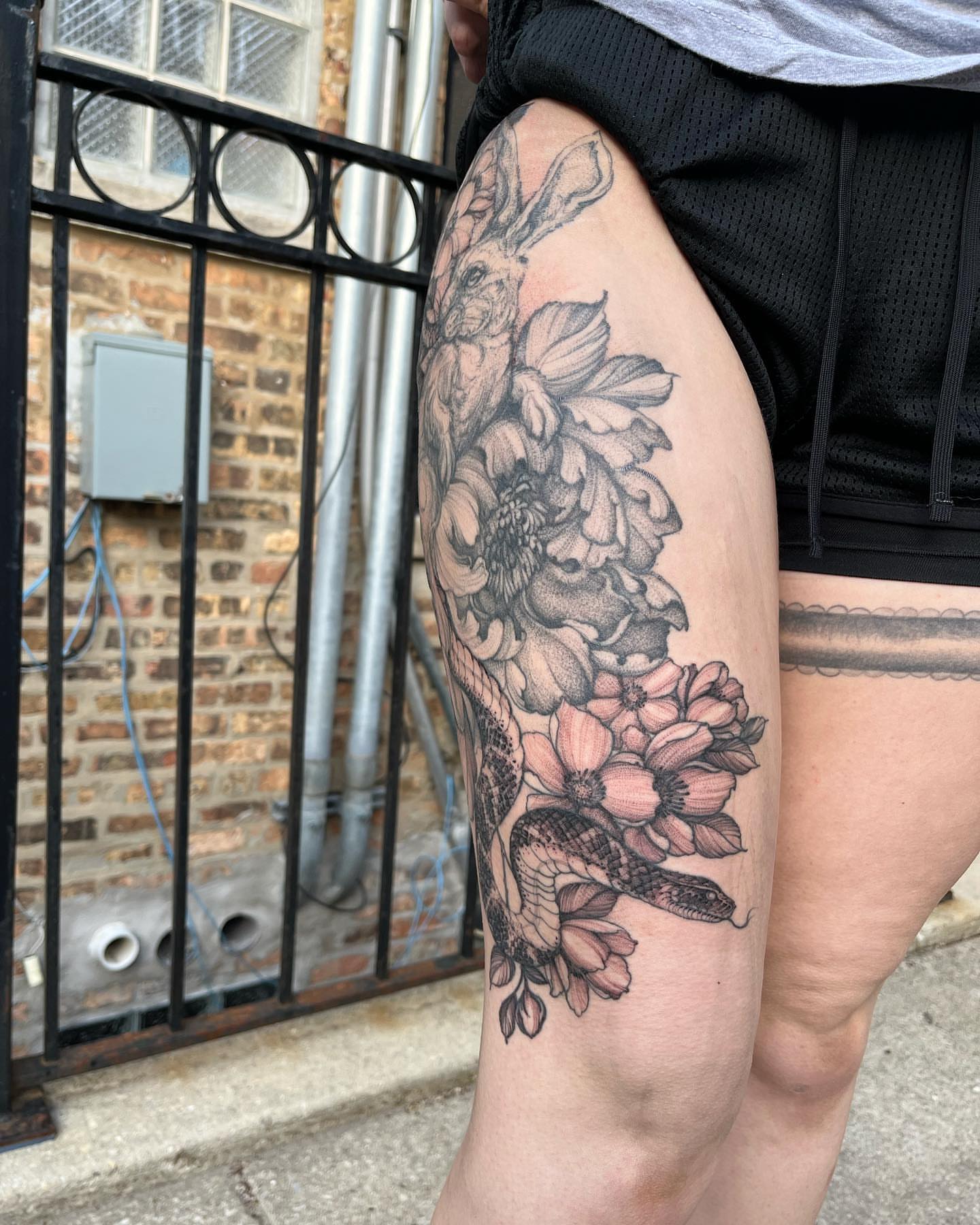 Rabbit and flowers realism tattoo on the thigh by Sarah Spread