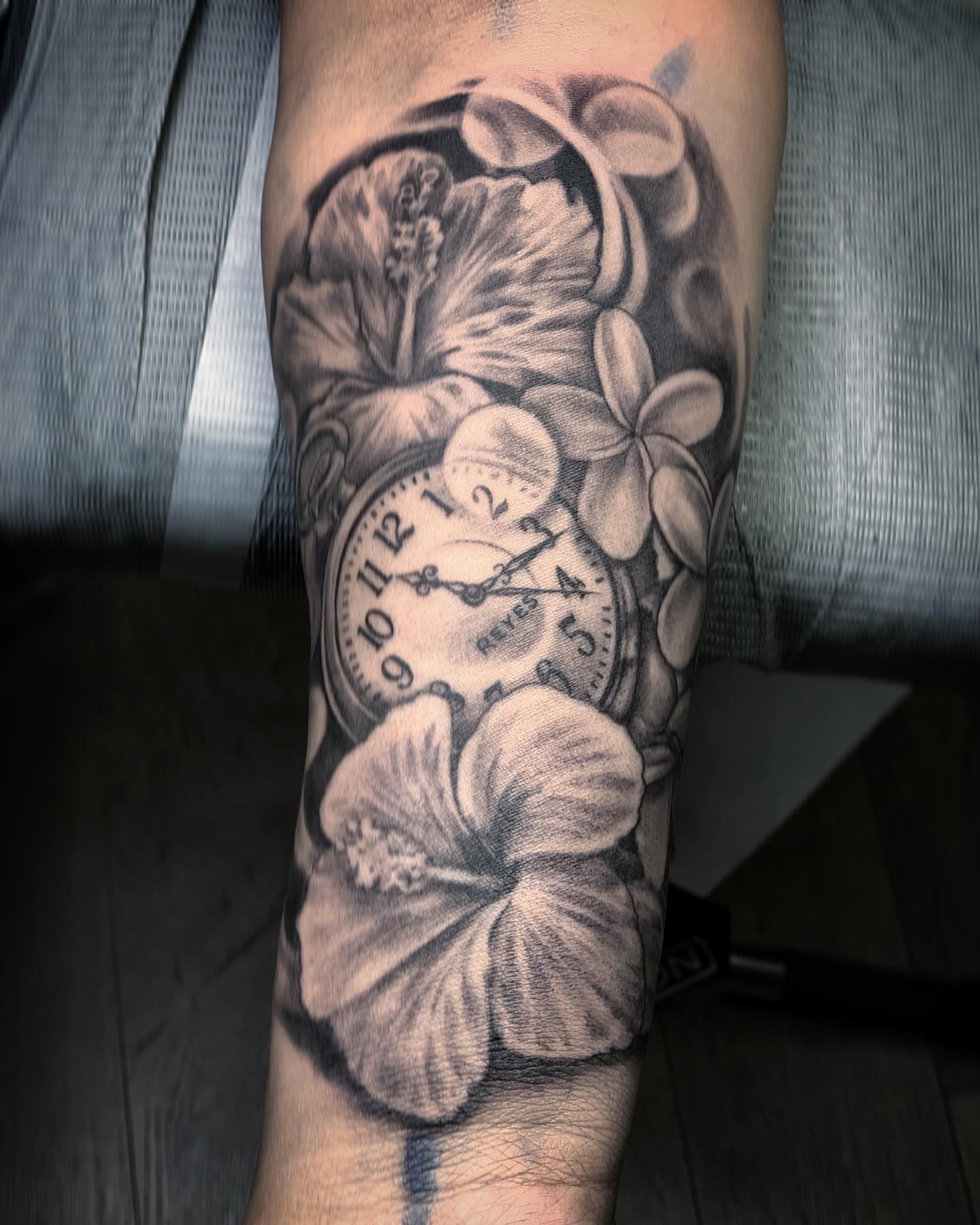 Clock and flowers realism tattoo on the forearm by TyEsha Reels