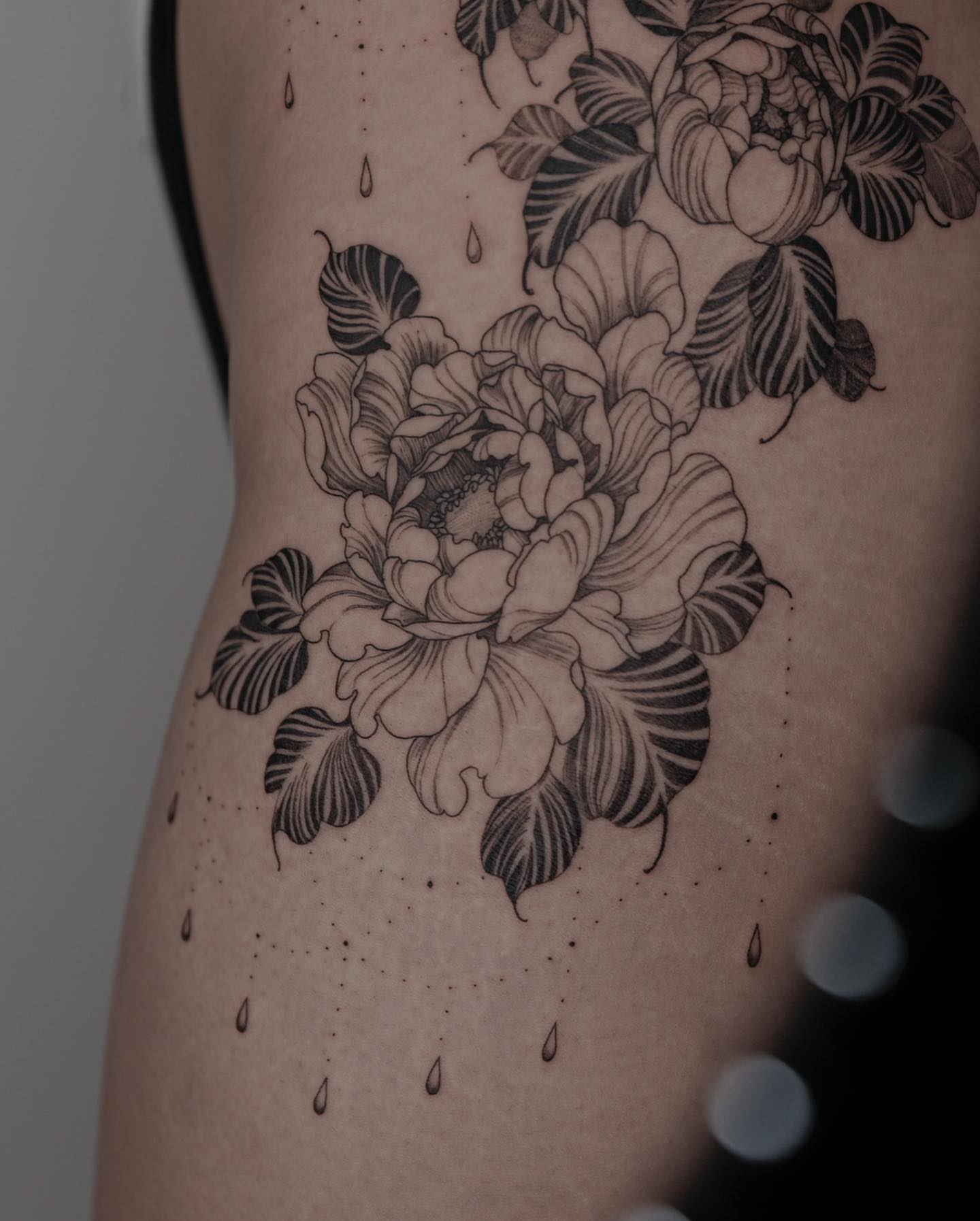 Peony flowers black and grey tattoo on the ribs by Zay - Realistic tattoo Artist