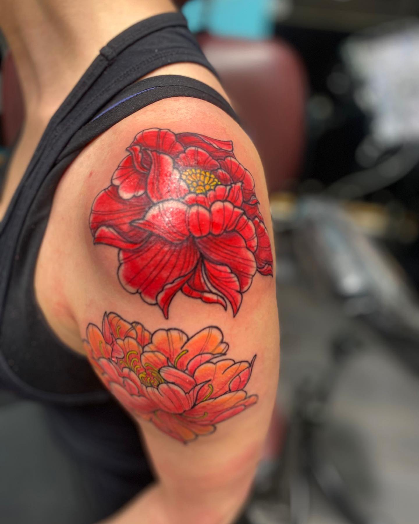 Red flowers realism tattoo on the shoulder by Alberto Ramirez