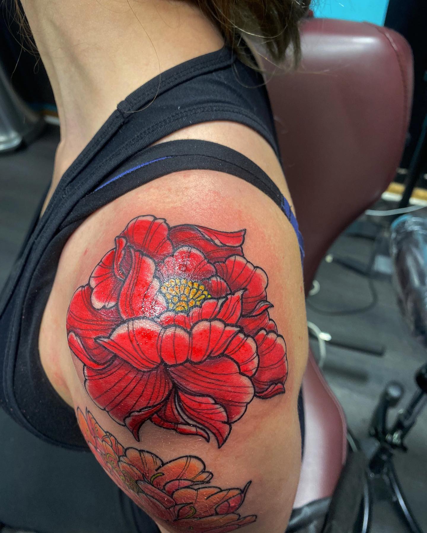 Red flower realism tattoo on the shoulder by Alberto Ramirez