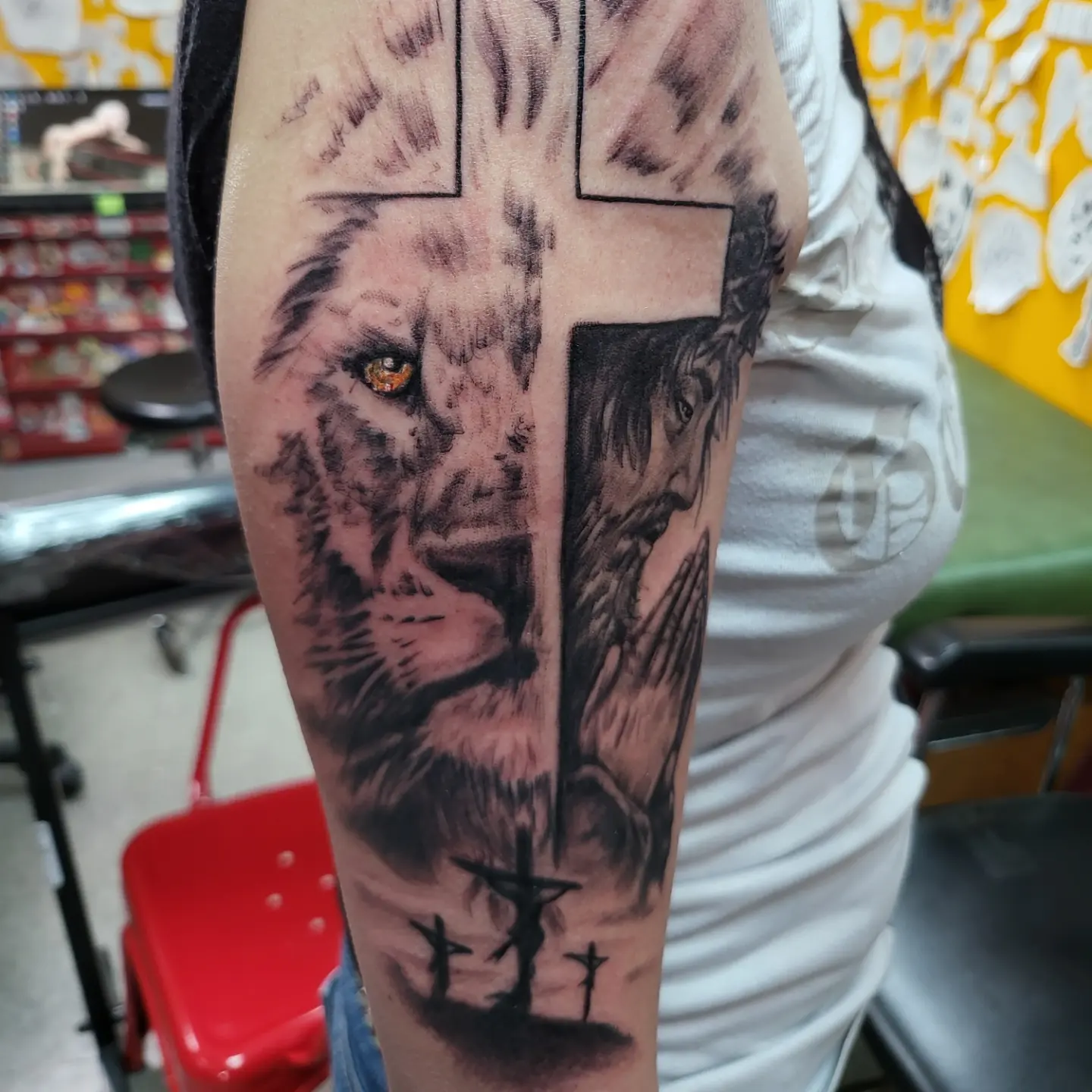 Lion and cross realism tattoo on the forearm by Mike Stamper