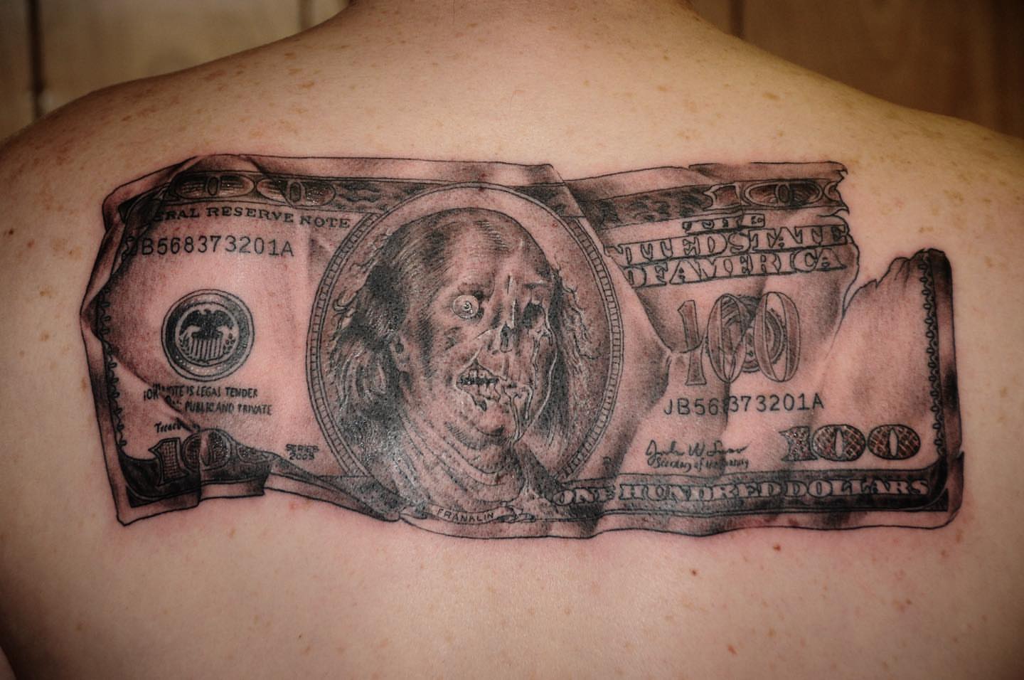 Hundred-dollar bill realism tattoo on the back by Trevor Sibary