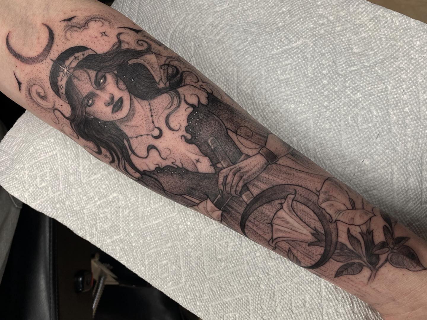 Woman with lilies dotwork tattoo on the forearm by Marissa Tattoos