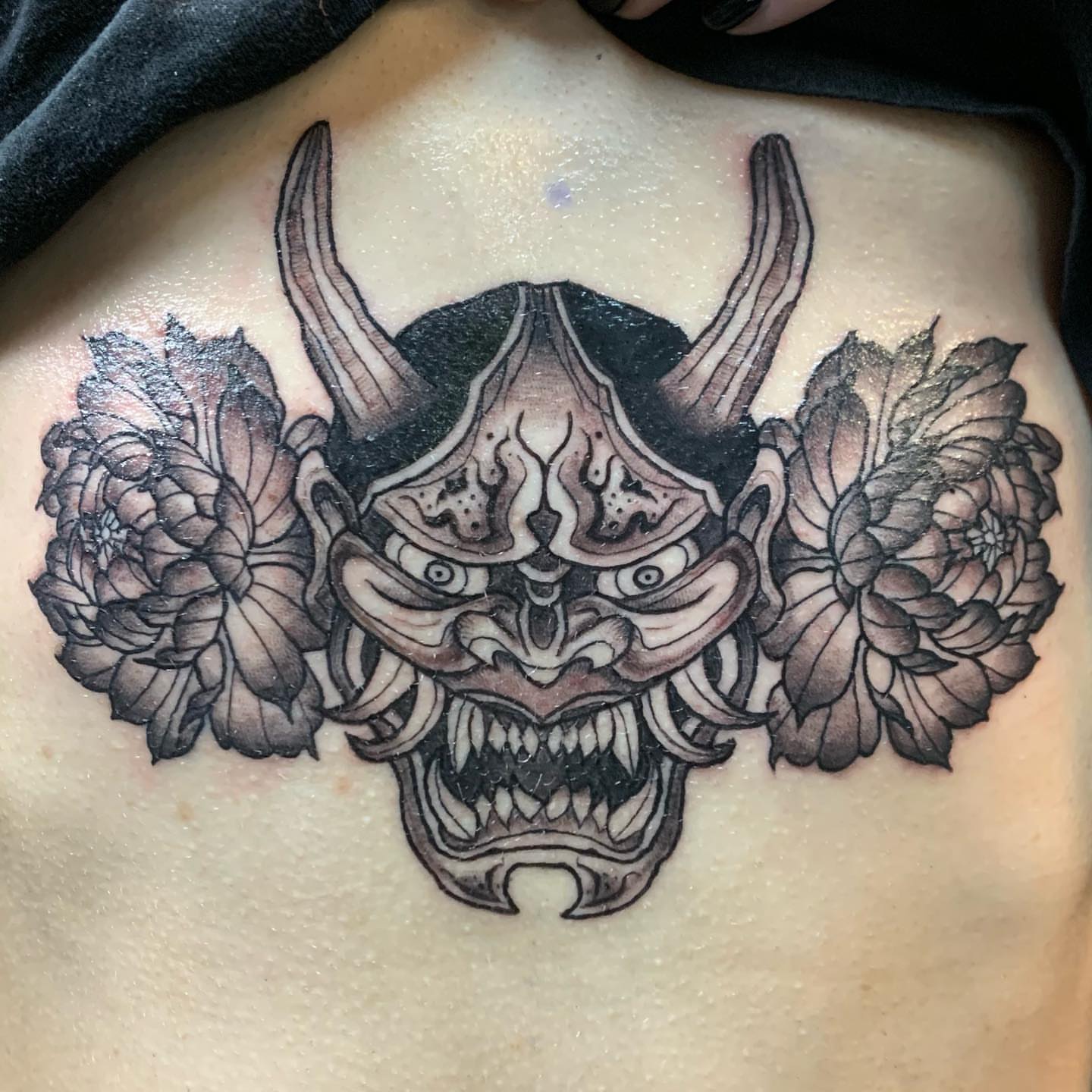 Mask with flowers black and grey tattoo on the chest by ដេវី  និល - Davi Nil - Tattoo Artist
