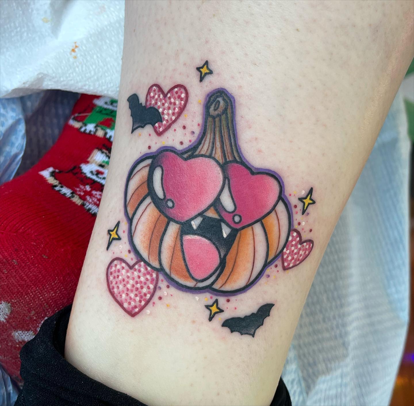 Pumpkin with hearts dotwork tattoo on the forearm by Erin Miller