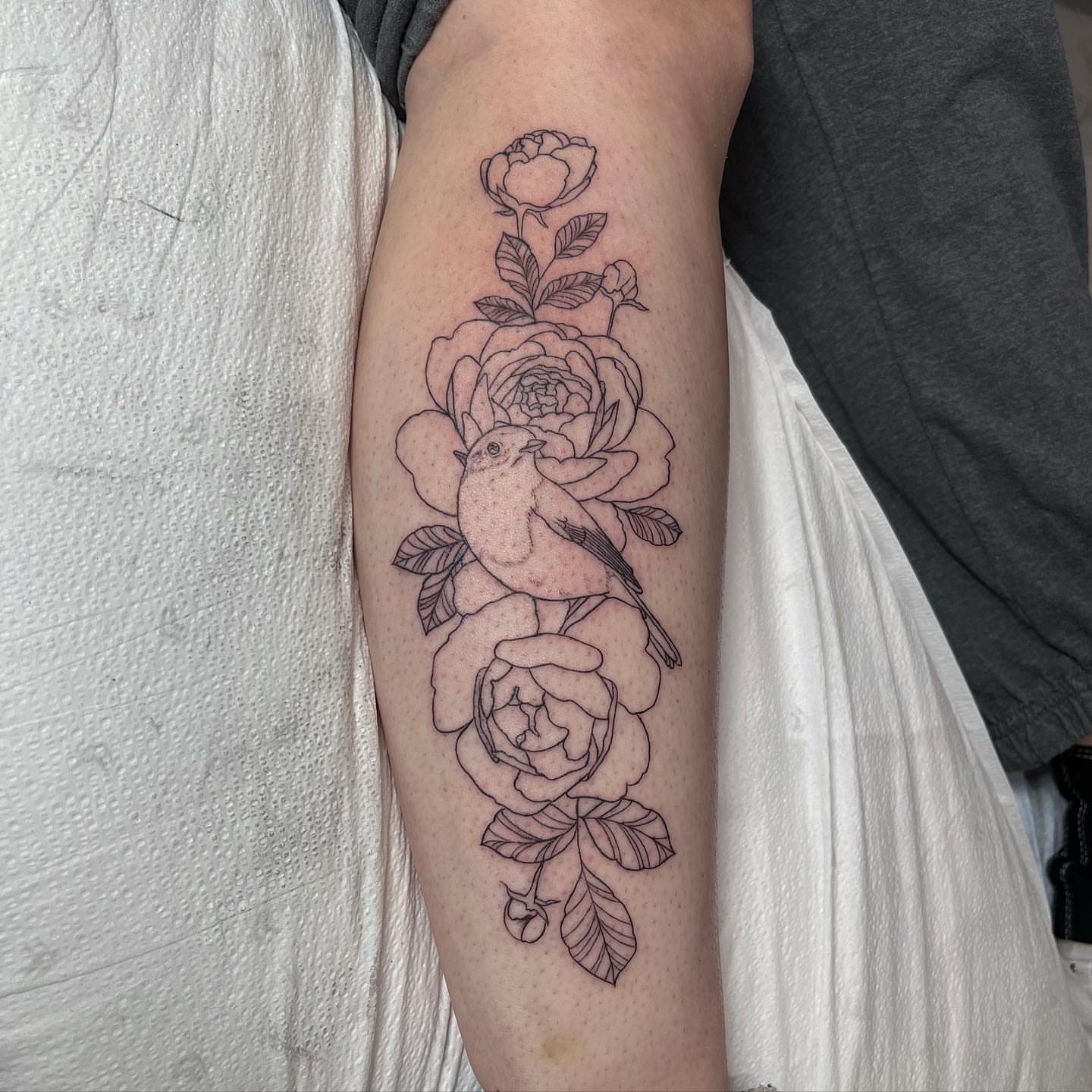 Peony and bird black and grey tattoo on the forearm by Mia