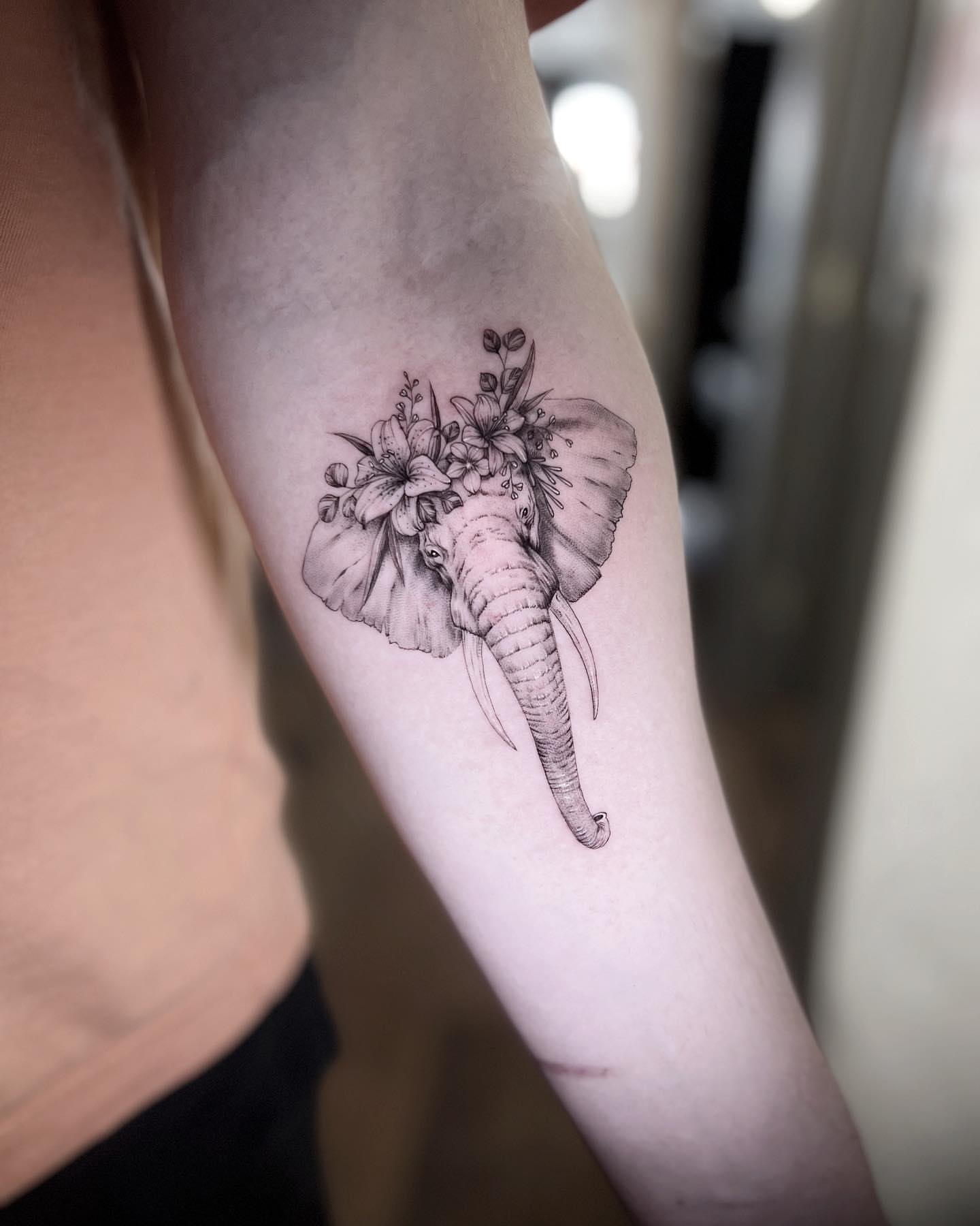 Elephant with flowers realism tattoo on the forearm by Nana
