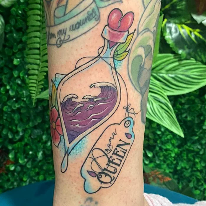 Bottle with waves and flower American traditional tattoo on the forearm by Marta La Jirafa