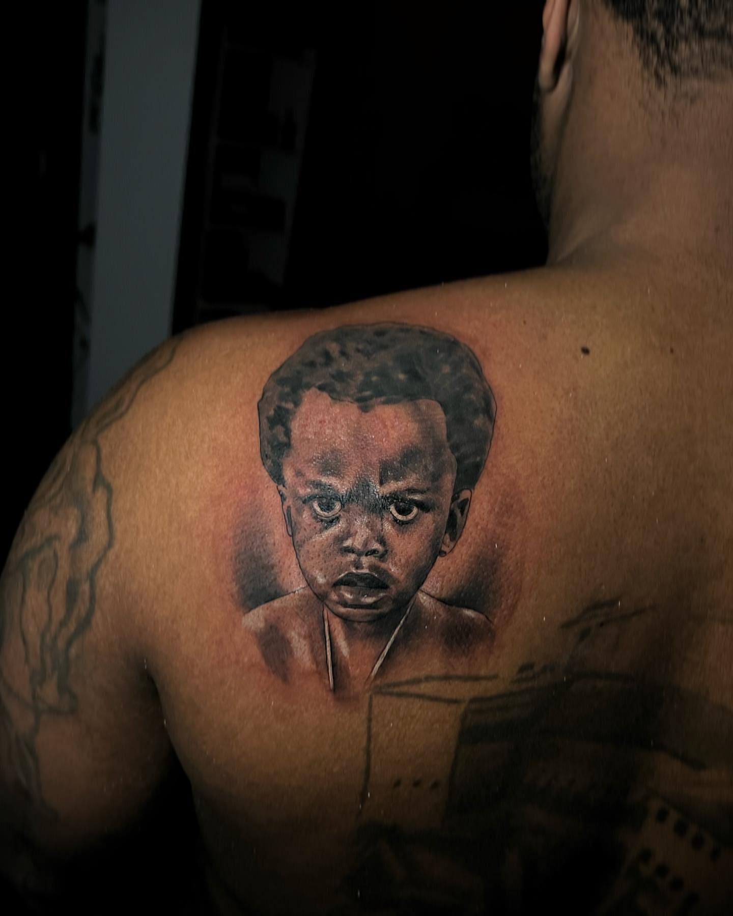 Child portrait realism tattoo on the shoulder by "CAM", West Palm Beach, Florida