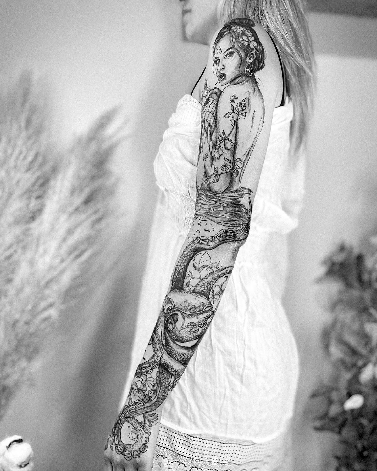 Woman with floral headdress realism tattoo on the upper arm by Ayauna Mai