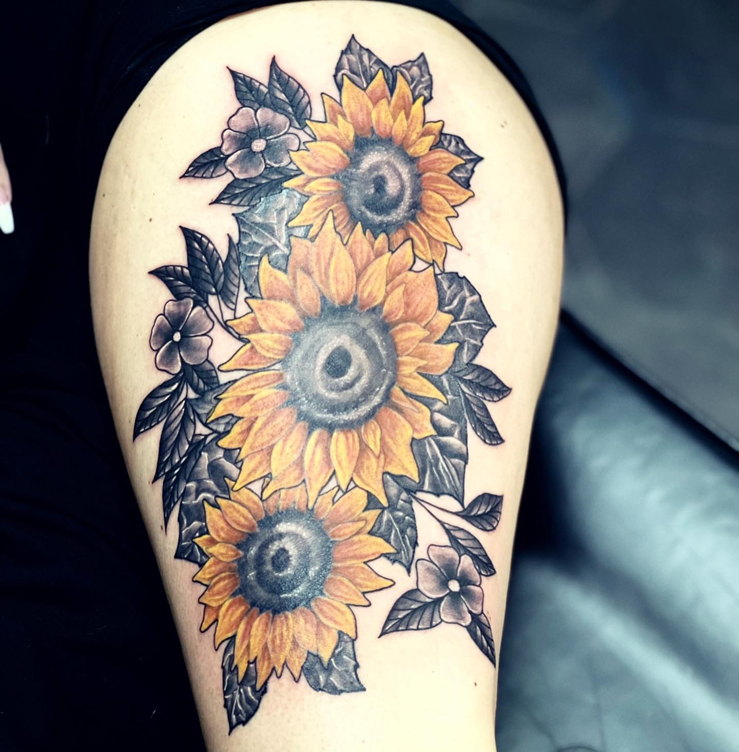 Sunflowers realism tattoo on the thigh by Peewee Morales