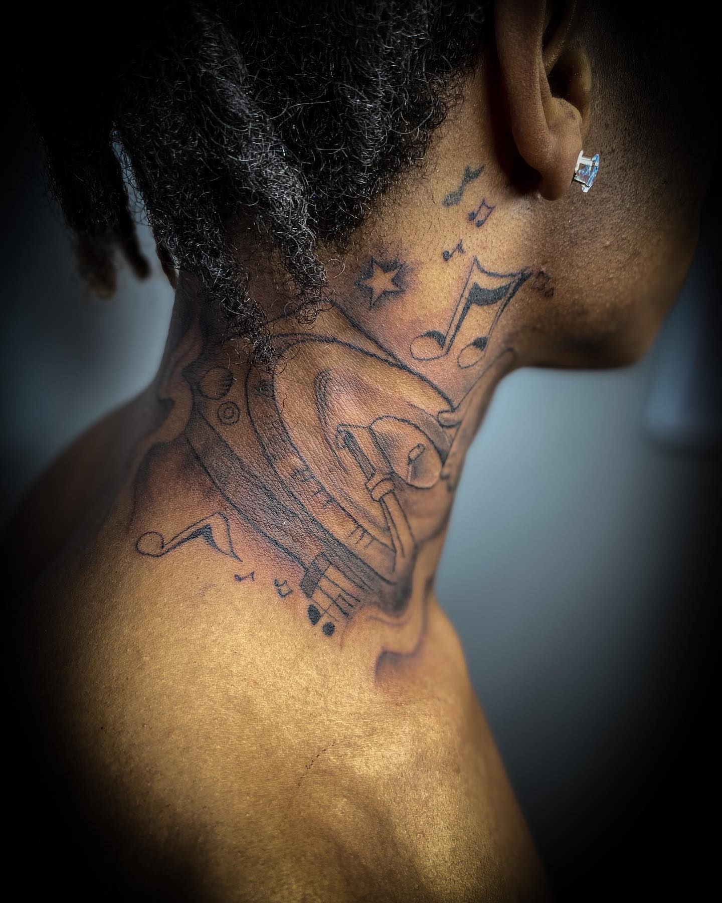 Music notes and stars black and grey tattoo on the neck by Traveling Tattoo Artist π