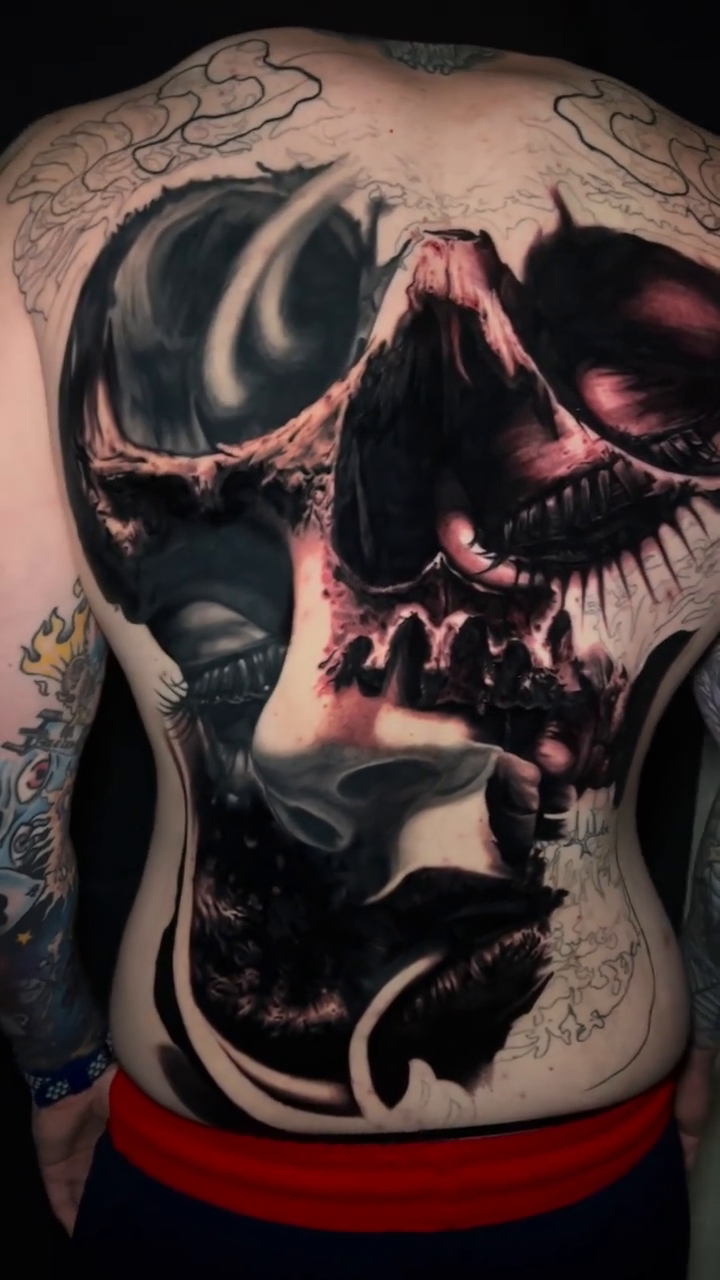 Skull and face fusion dark realism tattoo by Raul Ugarte, Roseville, California