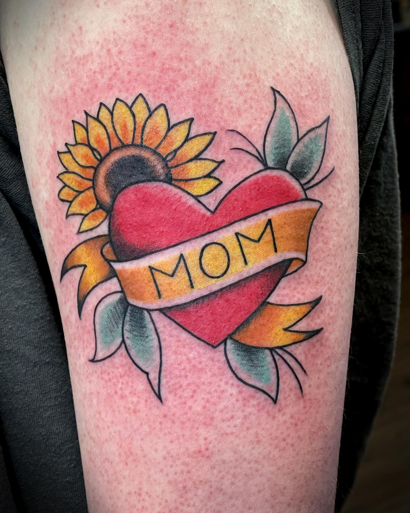 Heart with sunflower American traditional tattoo on the forearm by Dave Shurman