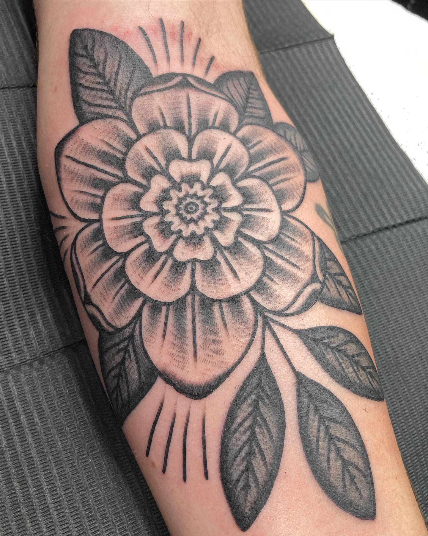 Flower American traditional tattoo on the forearm by Rob Banks
