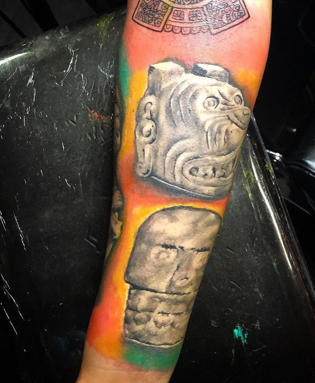 Ancient stone heads realism tattoo on the forearm by Visionary Tattoos