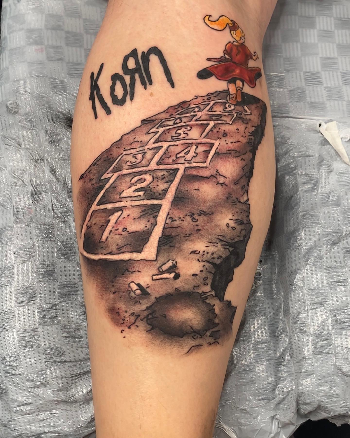 Hopscotch game realism tattoo on the forearm by Seth Scott