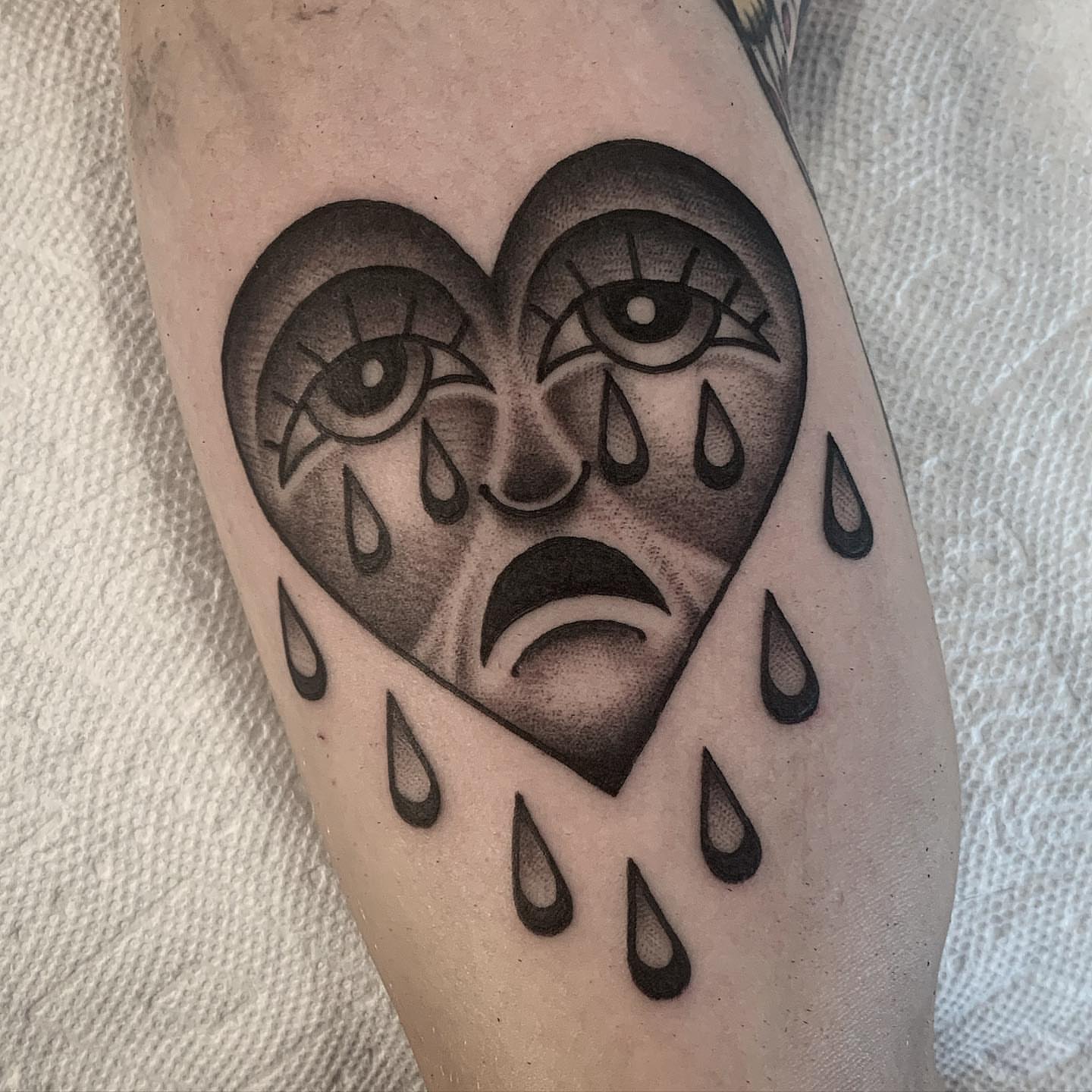 Tearful heart black and grey tattoo on the forearm by Pat Moser