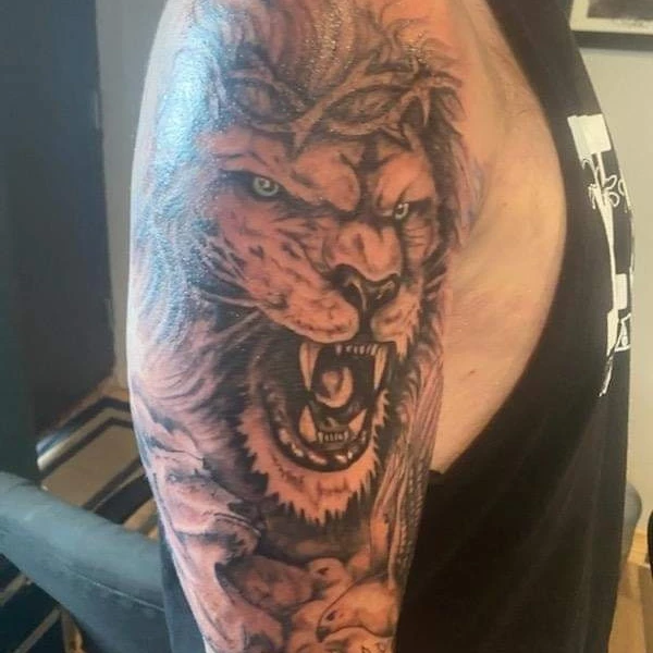 Roaring lion with crown realism tattoo on the chest by Russell Lucas