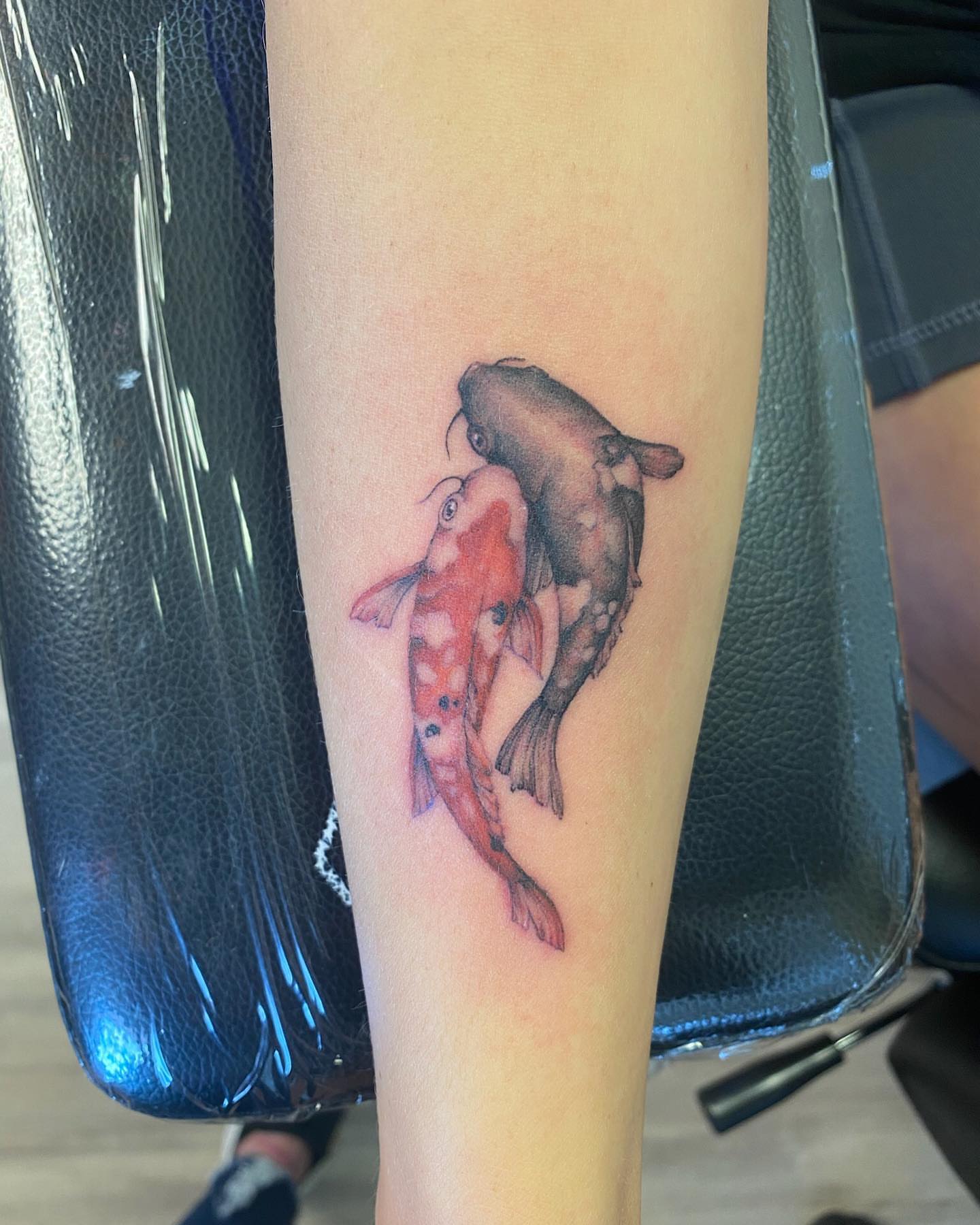 Koi fish realism tattoo on the forearm by Emily Conner
